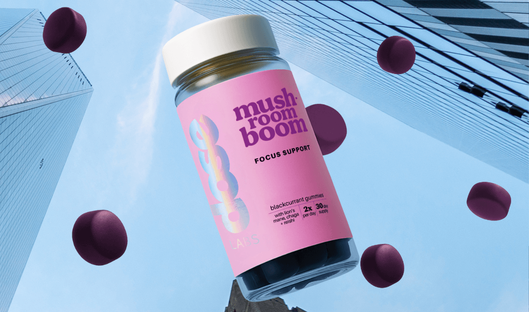 Mushroom Boom product bottles on a green background with purple confetti-like shapes.