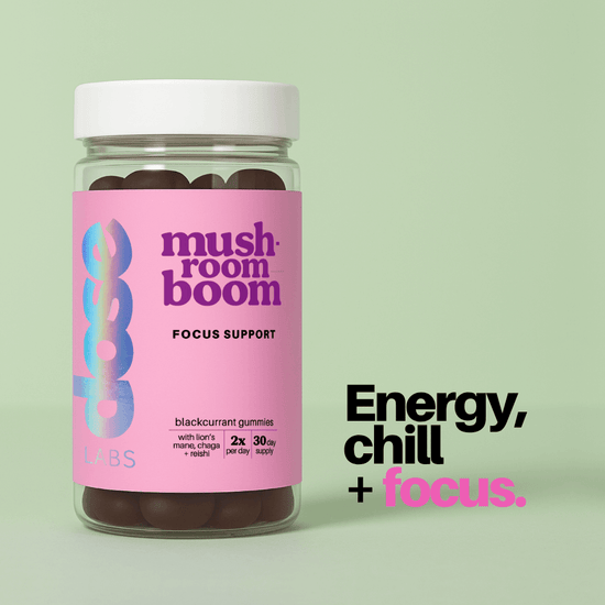 Jar of 'mushroom boom' gummies with pink label on a light green background