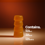 Stack of orange gummy vitamins with vitamin information on a brown background
